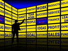 Bild zeigt einen Mann vor Bildchirmen, die viele Schlagworte anzeigen