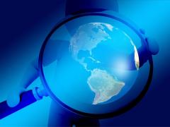 Bild Zeigt eine Lupe, in der die Welt vergrößert wird