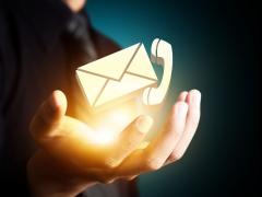 Bild mit einer geöffneten Hand, die die Symbole für Telefon und Email balanciert